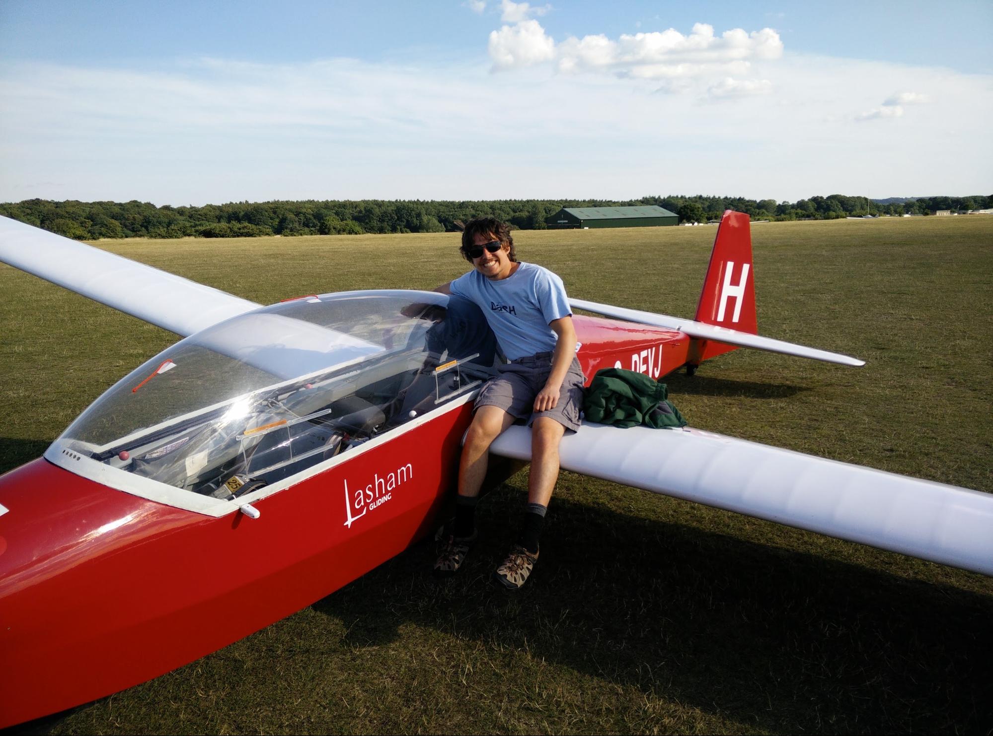 Me sitting on an ASK-13 glider at Lasham airfield in England